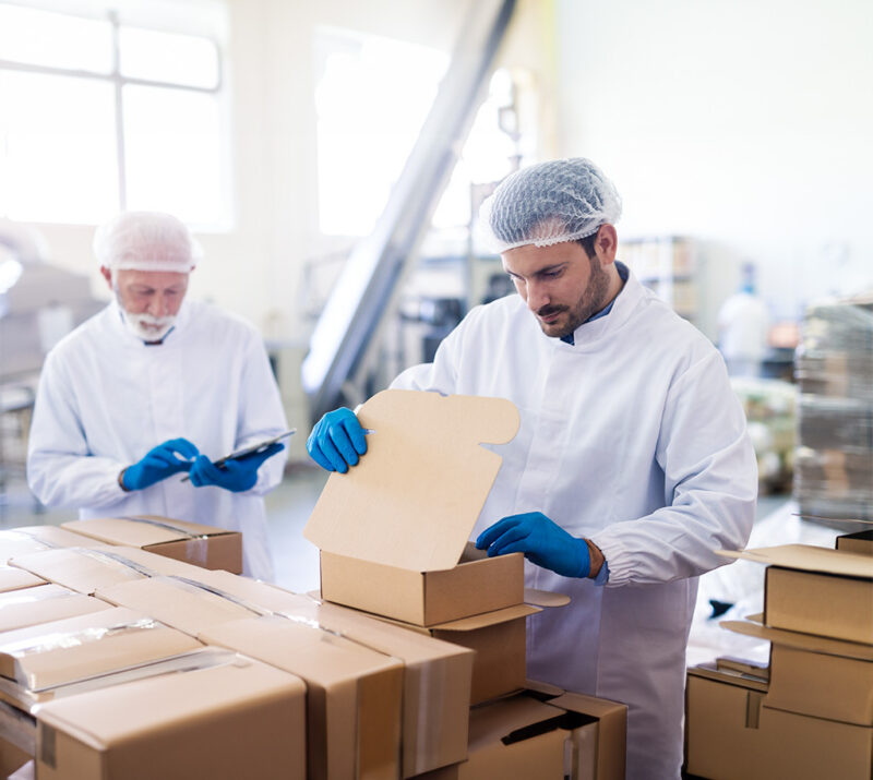 young caucasian employee sterile uniform packing goods boxes background supervisor holding tablet counting boxes