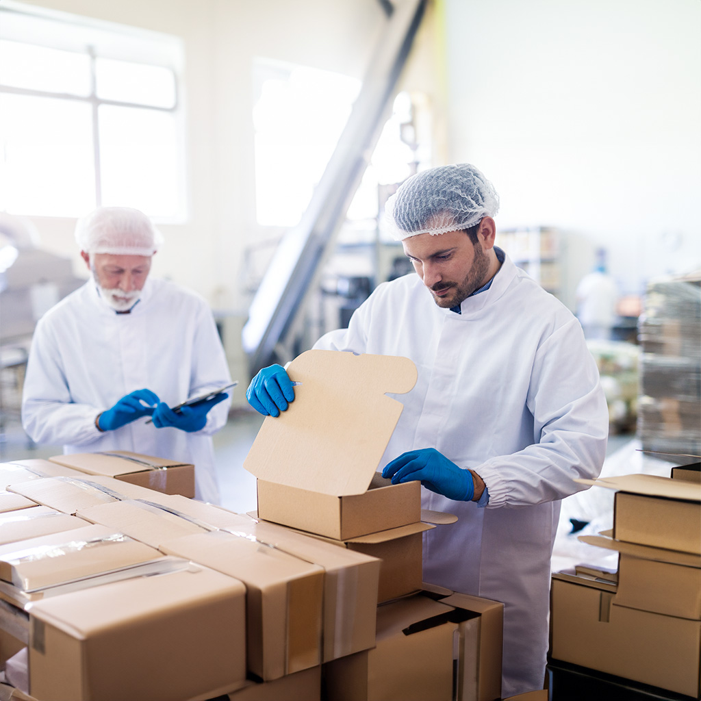 young caucasian employee sterile uniform packing goods boxes background supervisor holding tablet counting